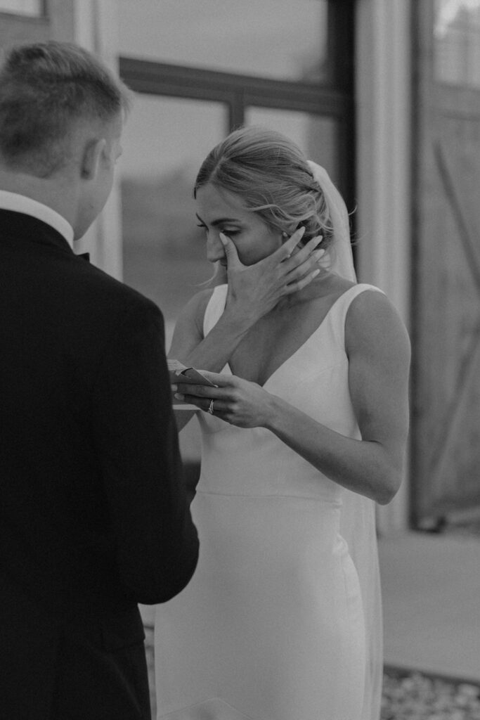 bride and groom exchanging private vows with a rustic barn wedding venue in the backdrop