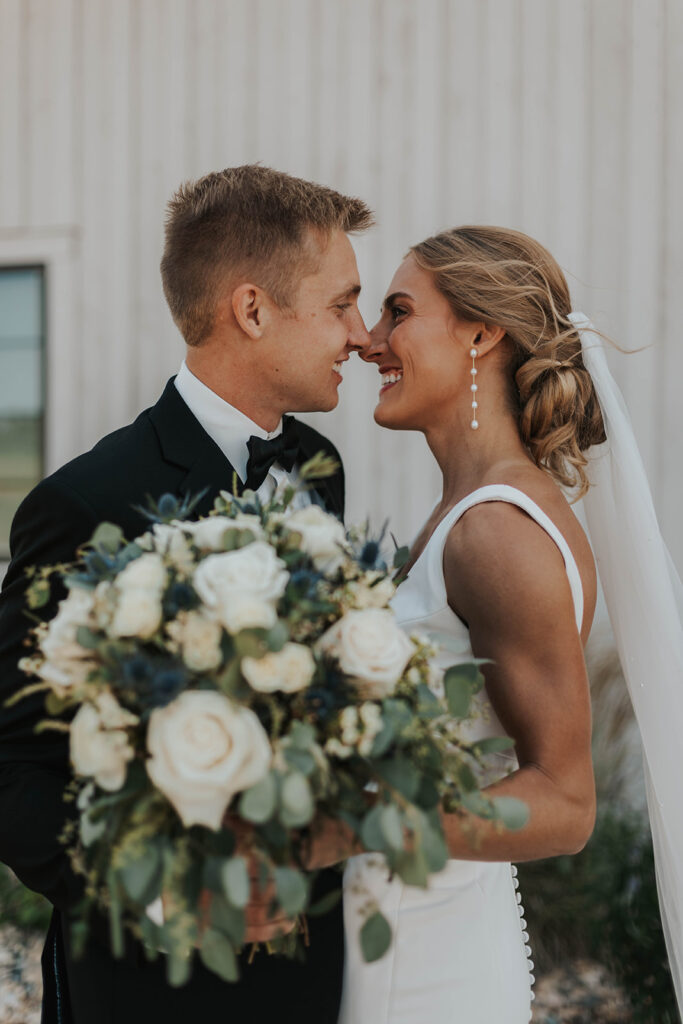 bride and groom exchanging private vows with a rustic barn wedding venue in the backdrop