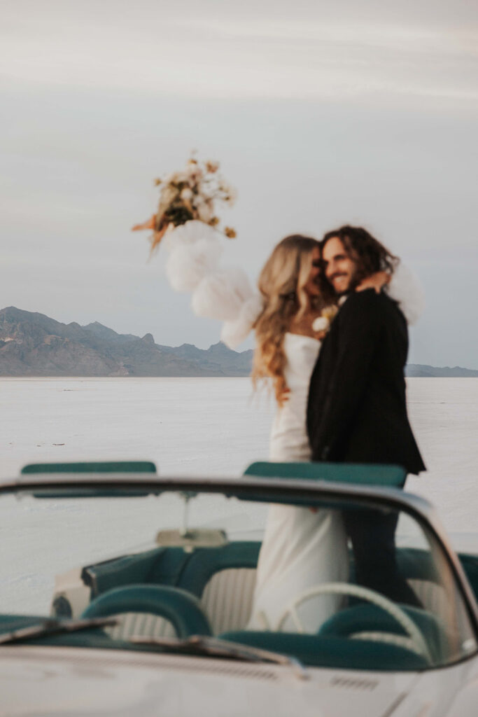 bride and groom salt flats elopement photo in a classic car