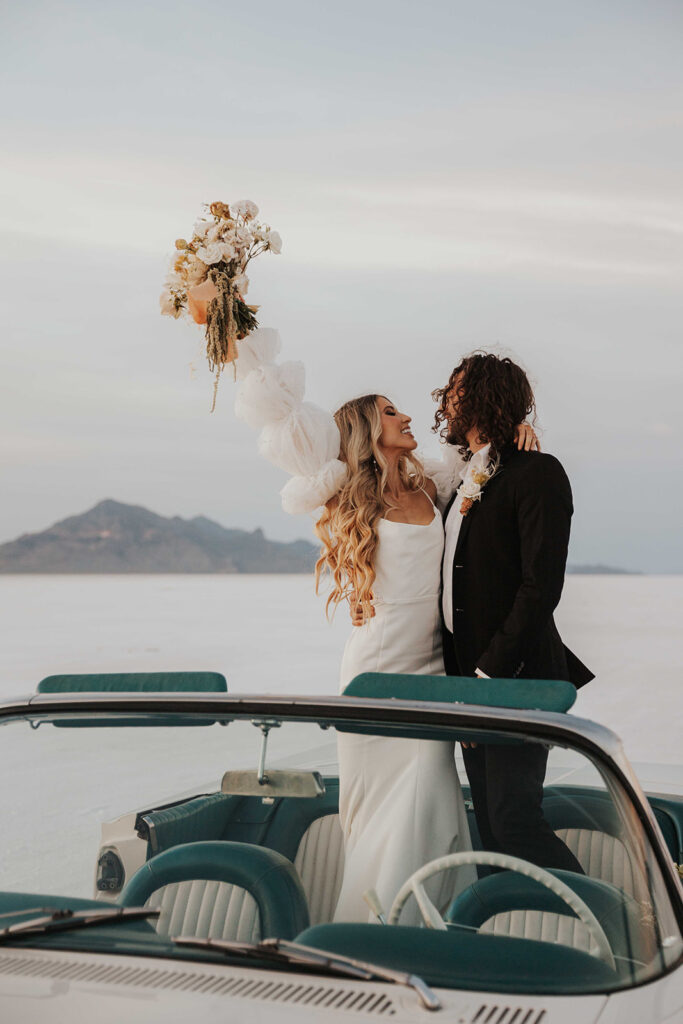 bride and groom salt flats elopement photo in a classic car