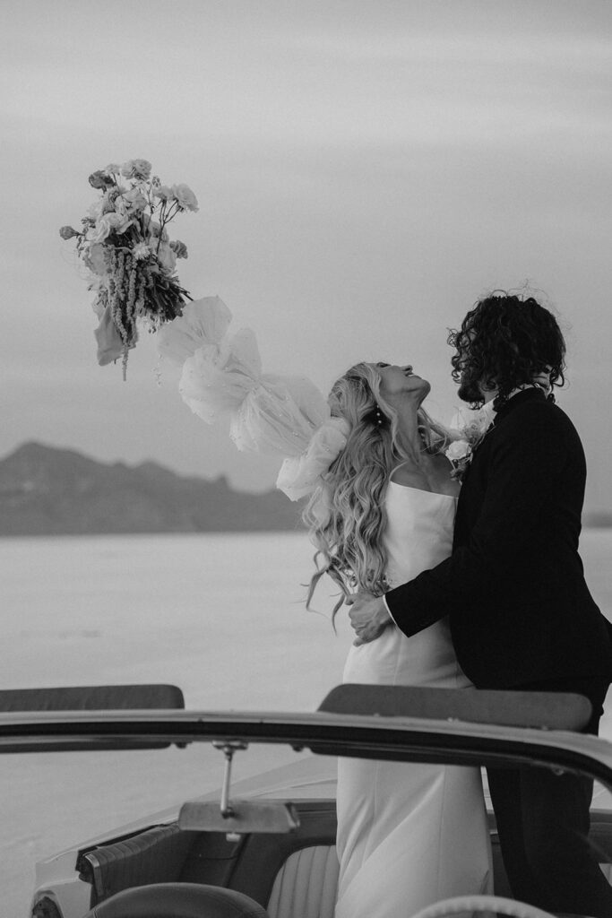 bride and groom salt flats elopement photo in a classic car