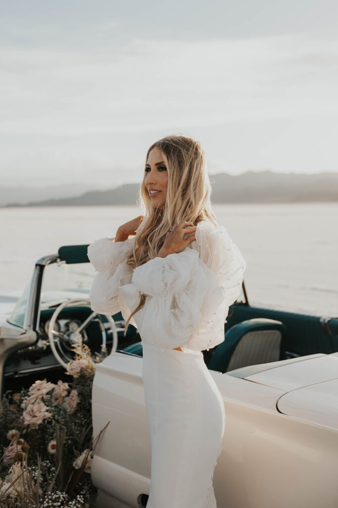 bride standing by a classic car 