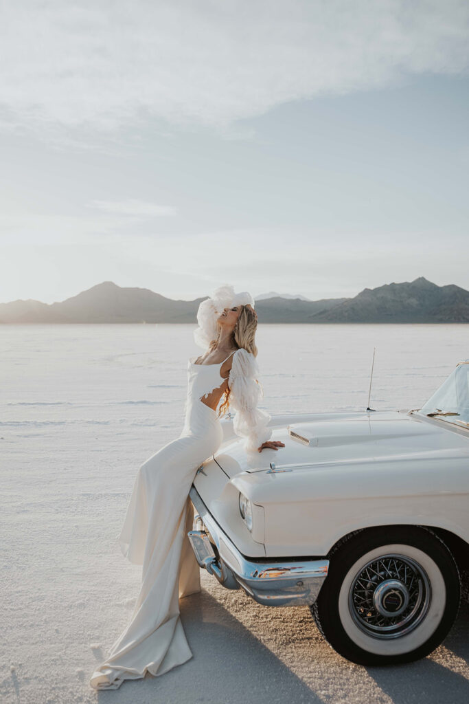 bride sitting on the hood of a classic car