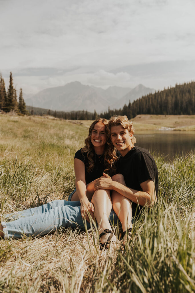 caleb and lauren sitting in a grassy field 