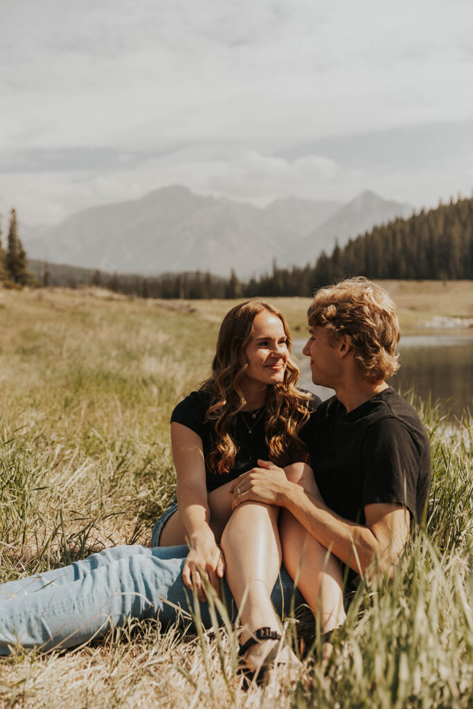 caleb and lauren sitting in a grassy field 