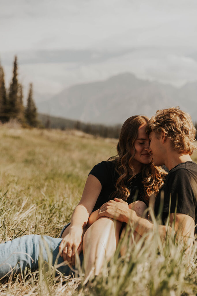 caleb and lauren sitting in a grassy field 