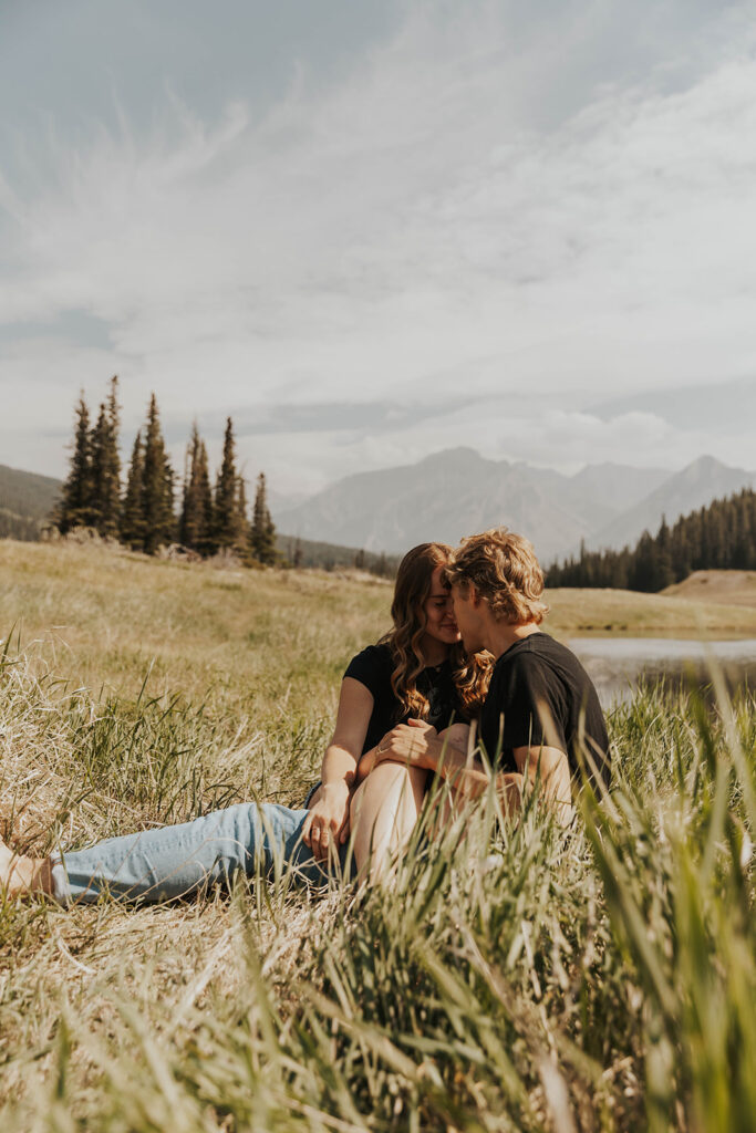 caleb and lauren sitting in a grassy field 