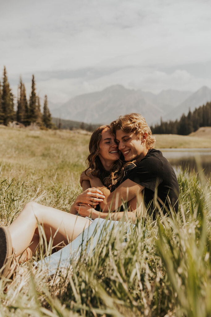 caleb and lauren sitting in a grassy field 