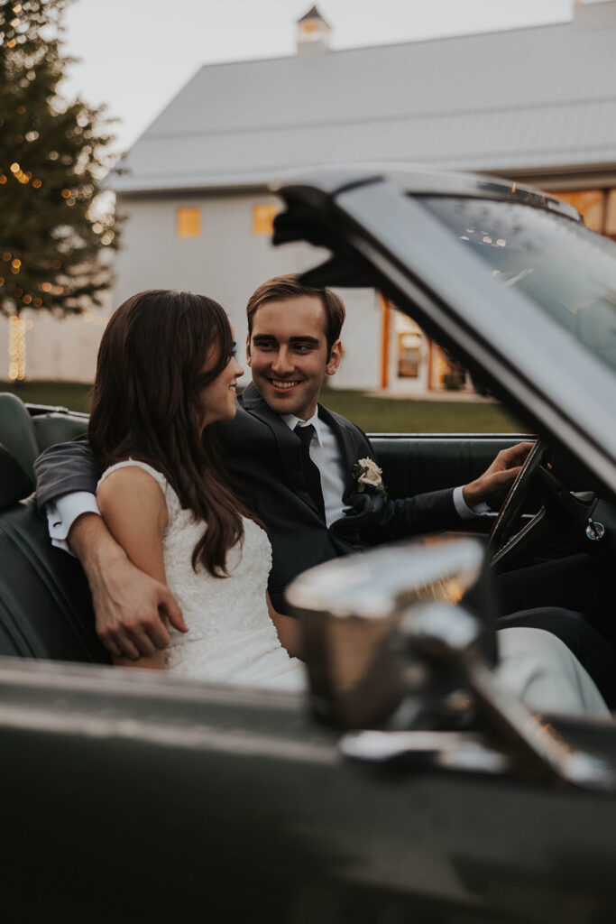 bride and groom preparing to drive away in a vintage car