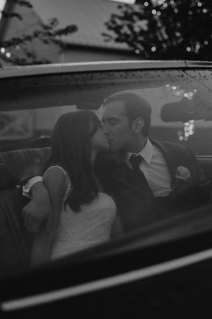 bride and groom preparing to drive away in a vintage car