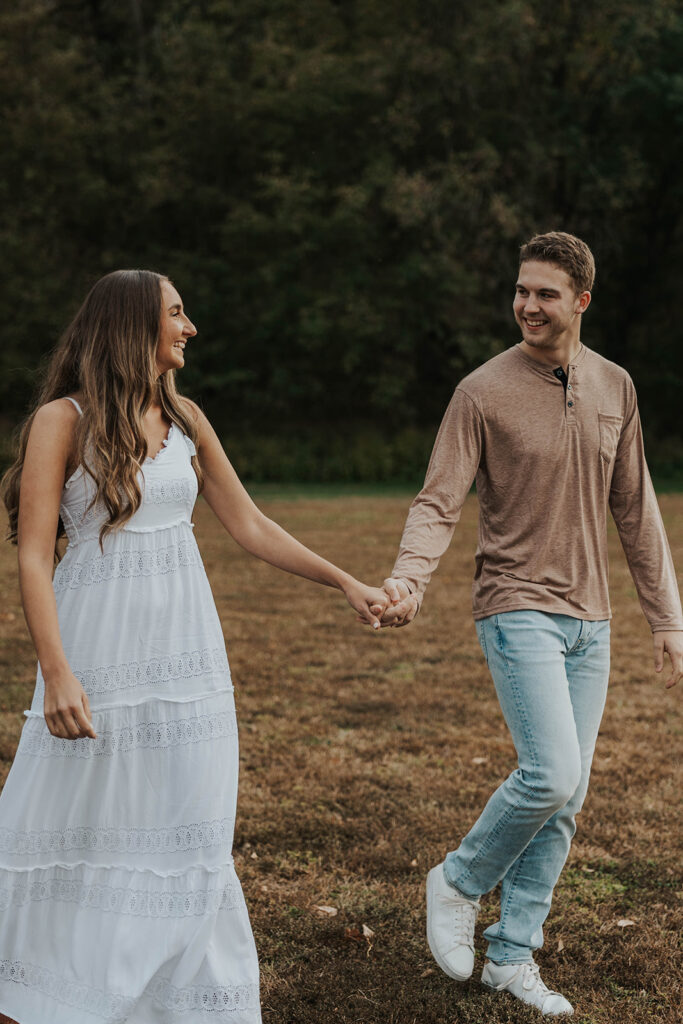 Sienna and Wyatt playing around in a park for their fall engagement session