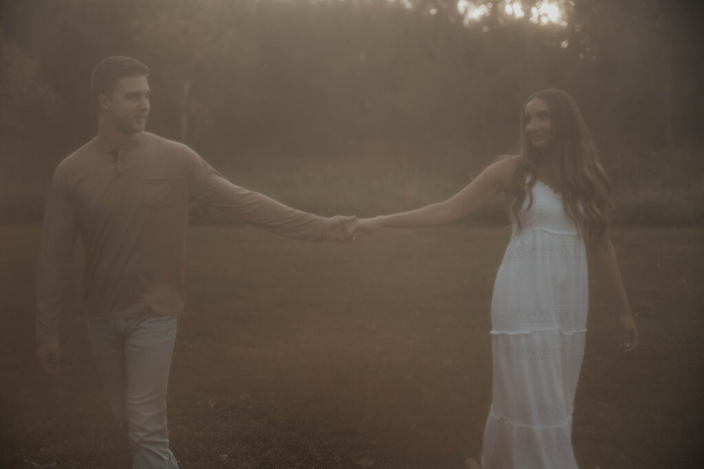 Sienna and Wyatt playing around in a park for their fall engagement session