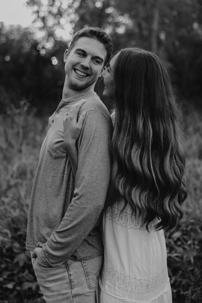 Sienna and Wyatt kissing each other playing around in a park for their fall engagement session