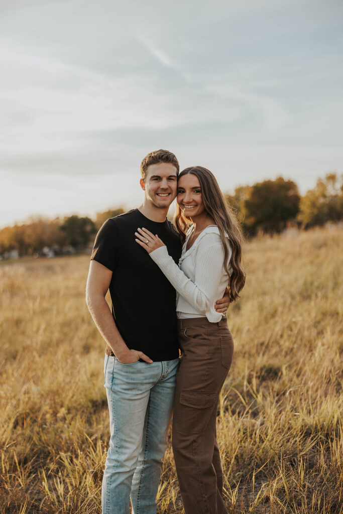 romantic engagement photos of Sienna and Wyatt in a golden field