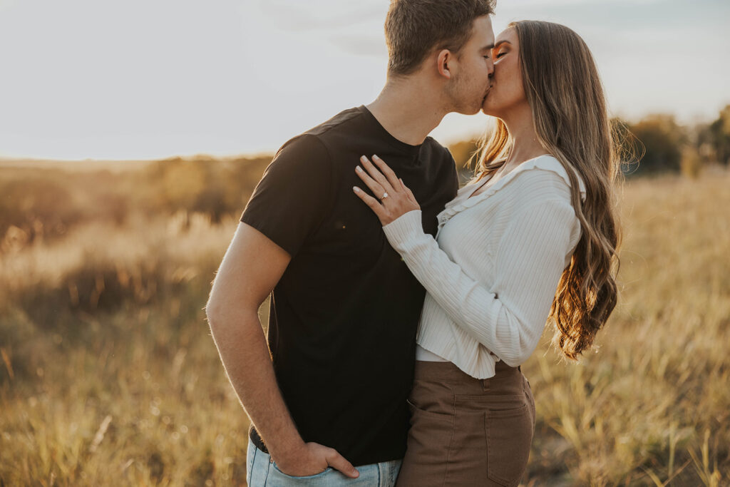 romantic engagement photos of Sienna and Wyatt in a golden field