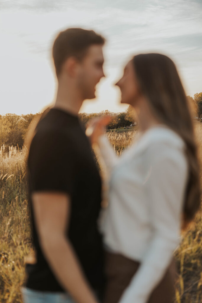 romantic engagement photos of Sienna and Wyatt in a golden field