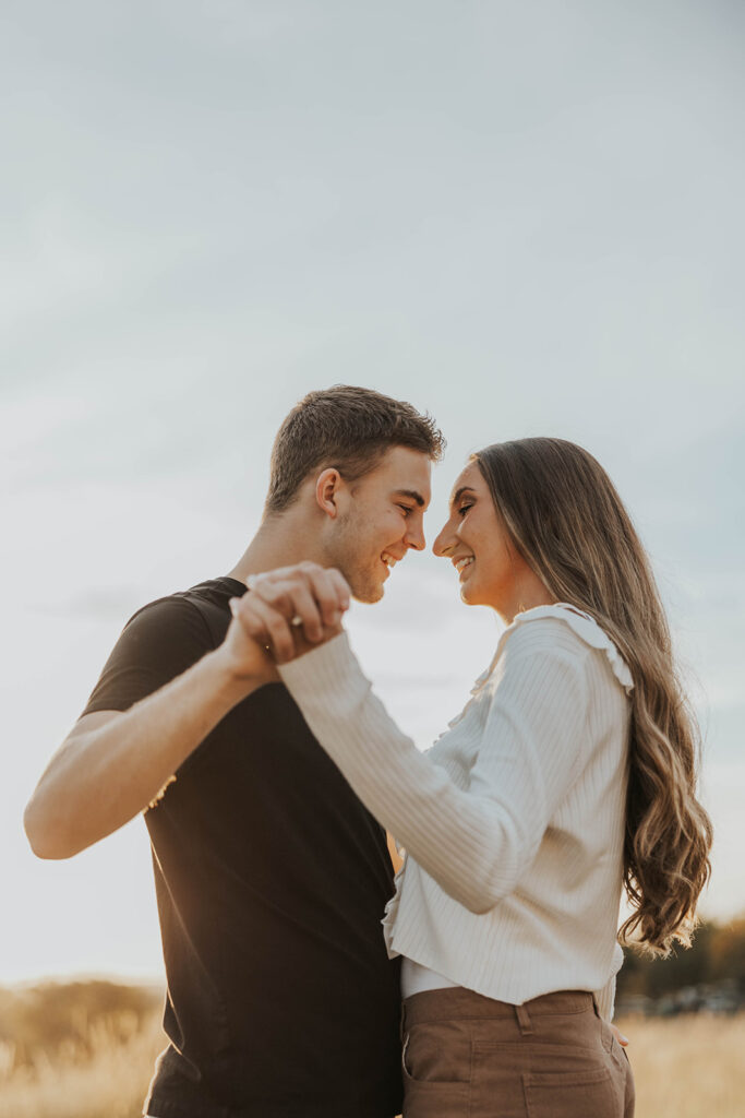 romantic engagement photos of Sienna and Wyatt in a golden field