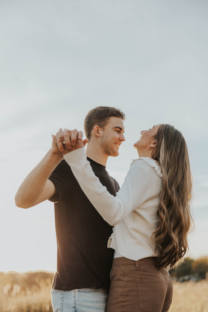 romantic engagement photos of Sienna and Wyatt in a golden field