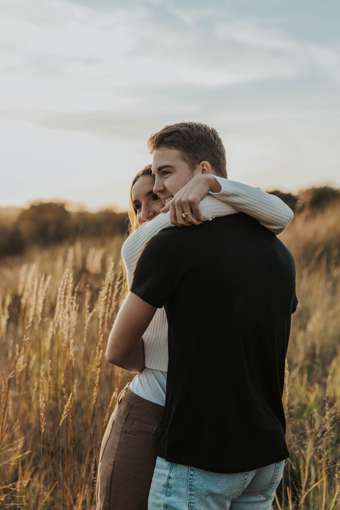 romantic engagement photos of Sienna and Wyatt in a golden field