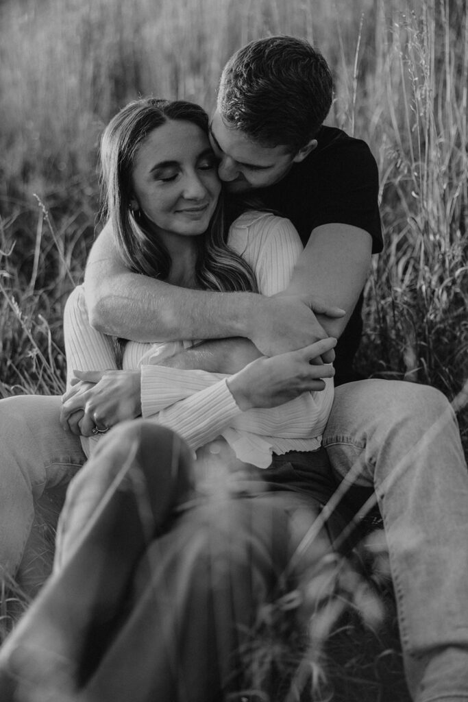 romantic engagement photos of Sienna and Wyatt sitting in a golden field