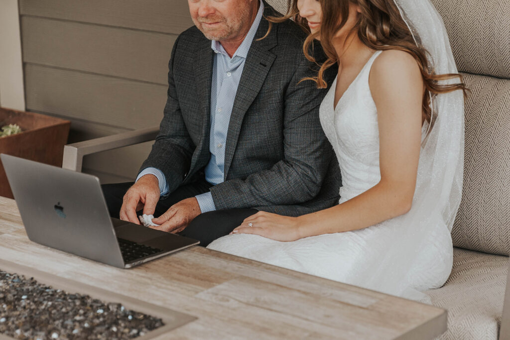 bride and dad going through a wedding slideshow