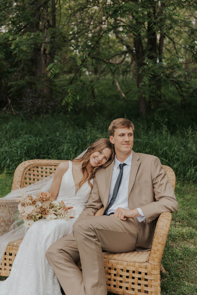 boho bride and groom outdoor photos on a wicker chair