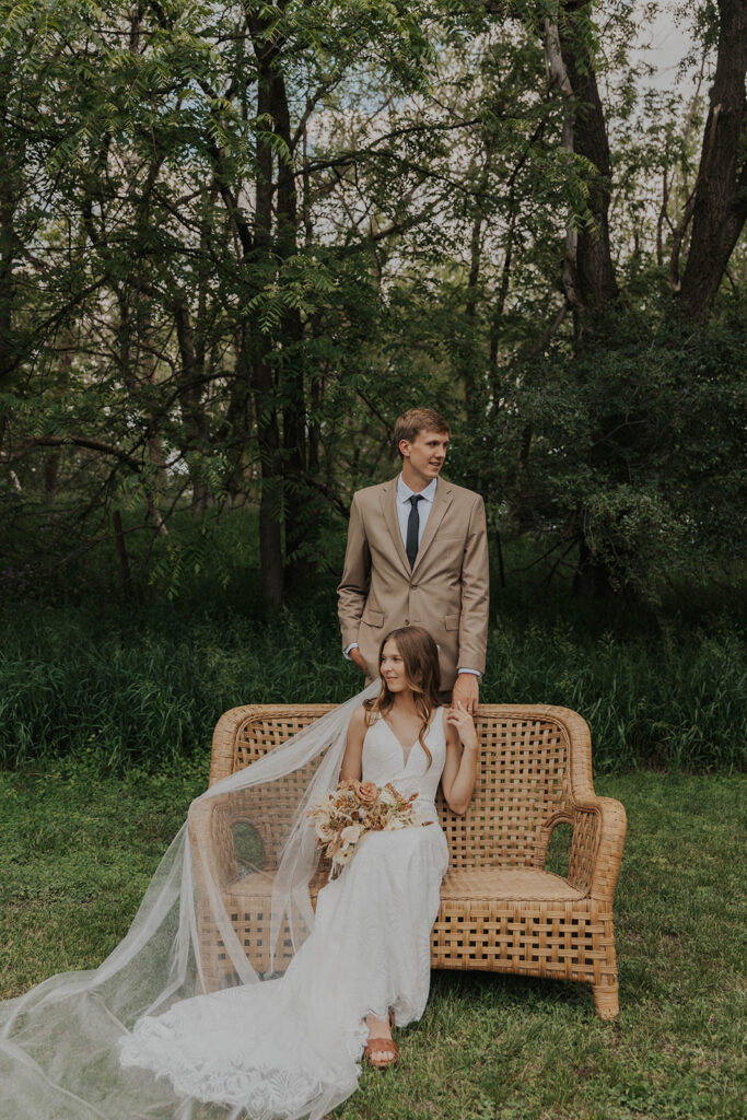 boho bride and groom outdoor photos on a wicker chair