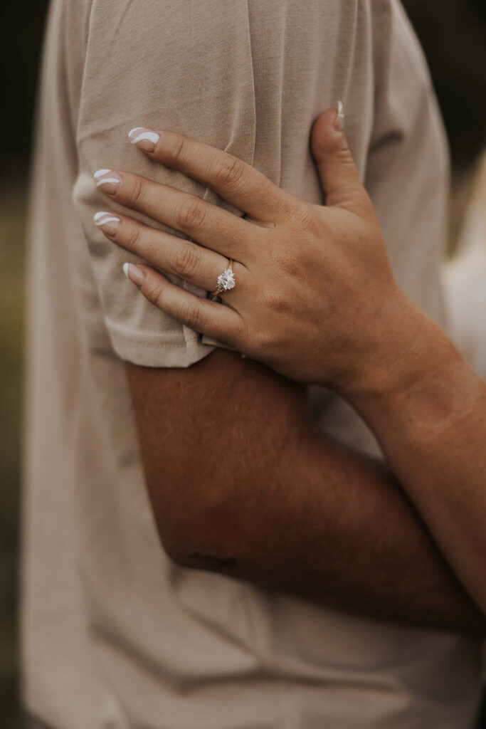 a cute and playful couple in a field during their Minnesota engagement session in Sibley State Park, captured by Cassie Beth: Minnesota Photographer