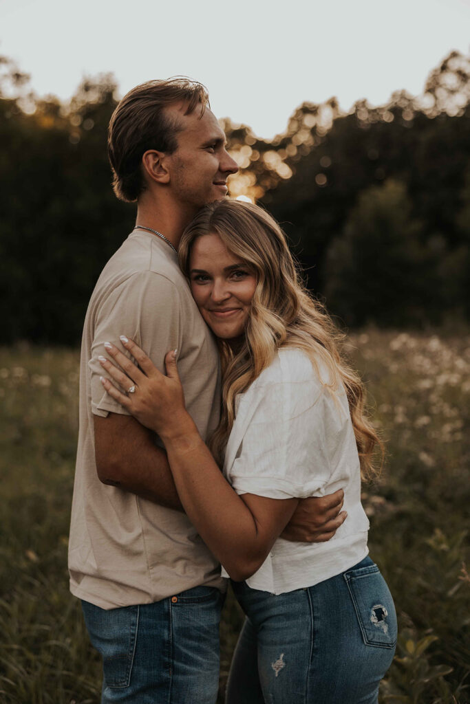 a cute and playful couple in a field during their Minnesota engagement session in Sibley State Park, captured by Cassie Beth: Minnesota Photographer