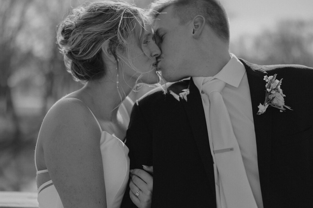 black and white candid bride and groom kiss