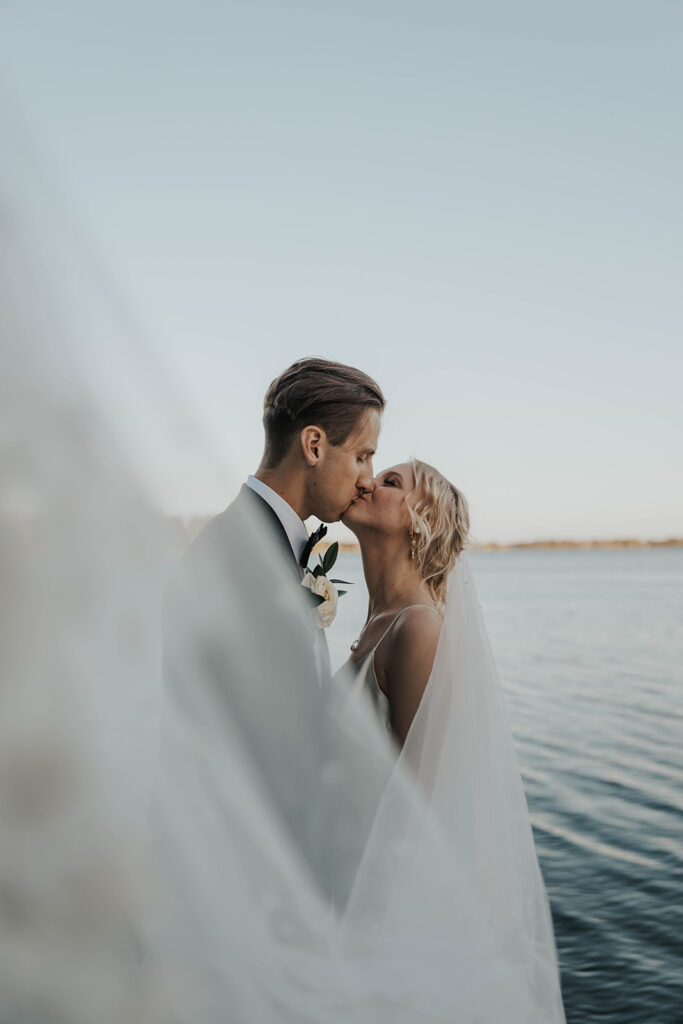 romantic bride and groom at a lake shore during their destination elopement wedding