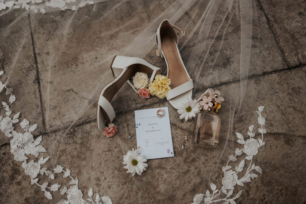 classy timeless wedding detail flatlay of shoes, bouquet, loose florals