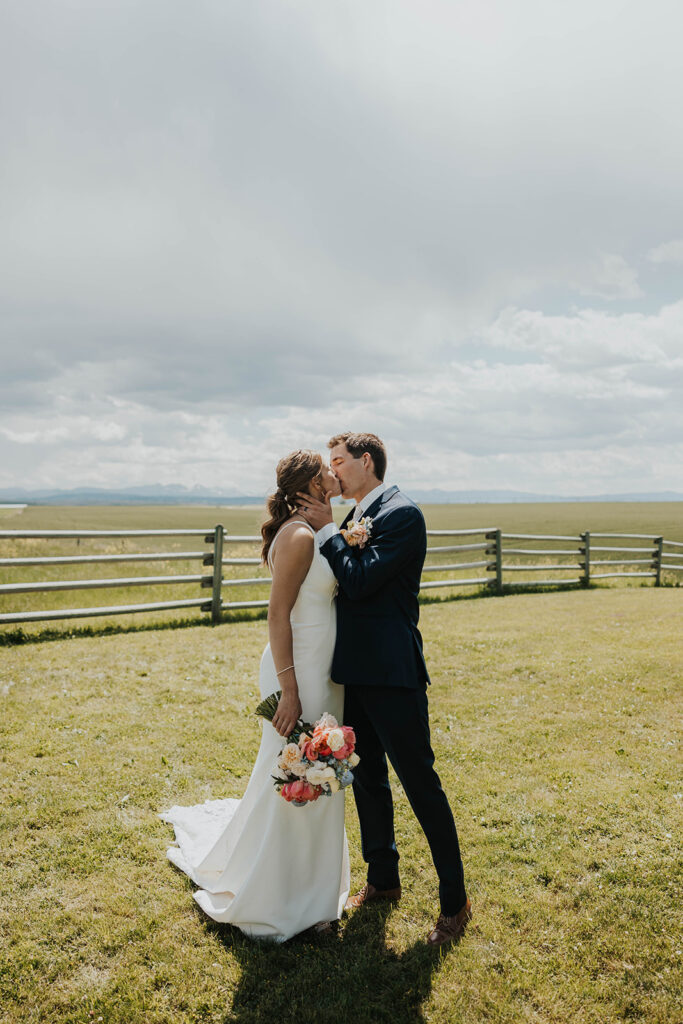 bride and groom kissing in a beautiful rustic field