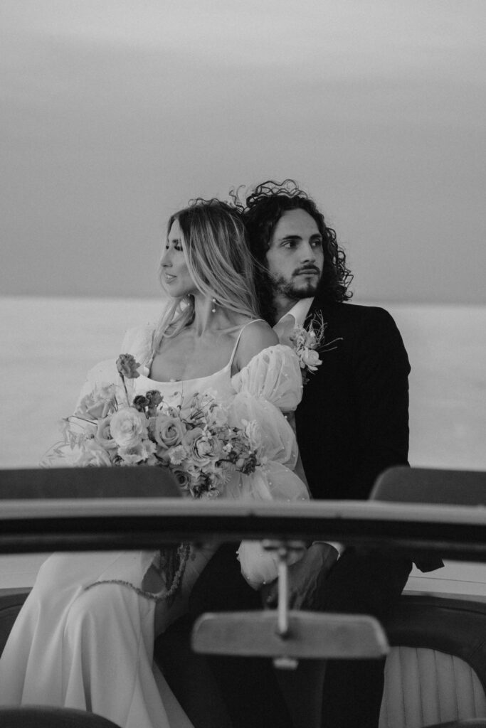 Black and white image of a couple sitting in a car at their elopement in Salt Flats, Utah