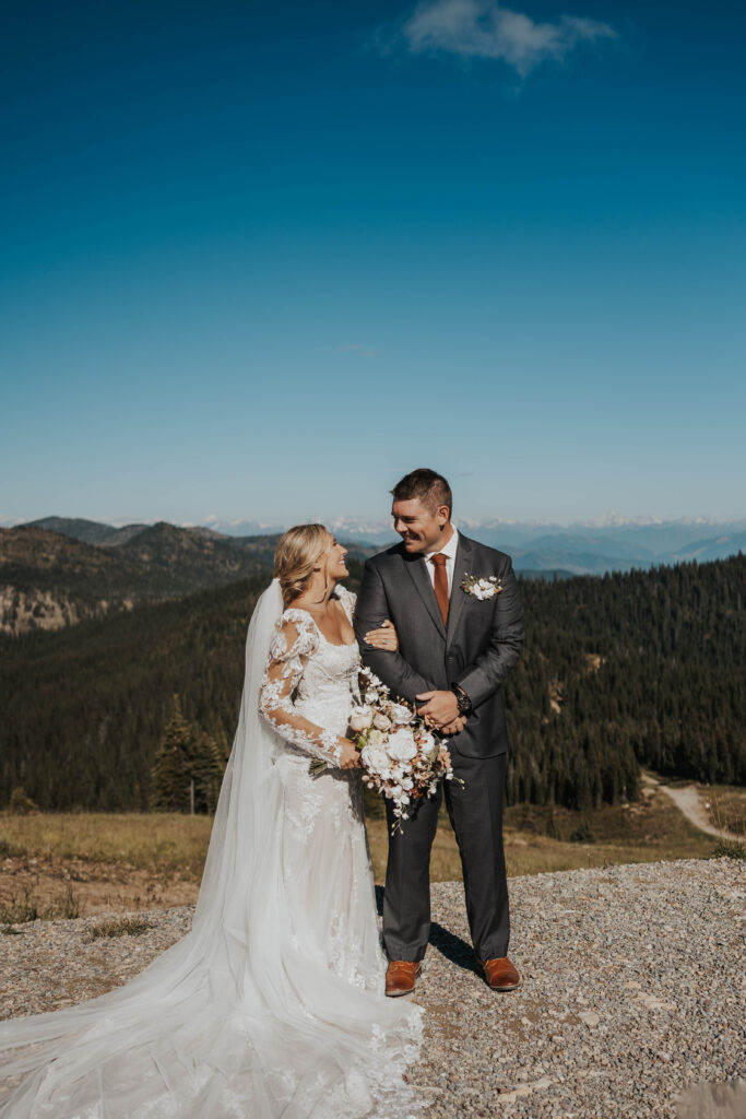 Couple looking at each other in front of mountains at Whitefish Mountain Resort