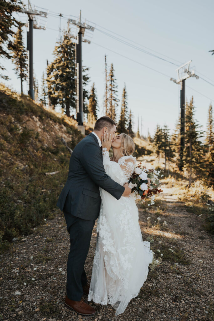 Couple kissing in front of a ski lift at Whitefish Mountain Resort