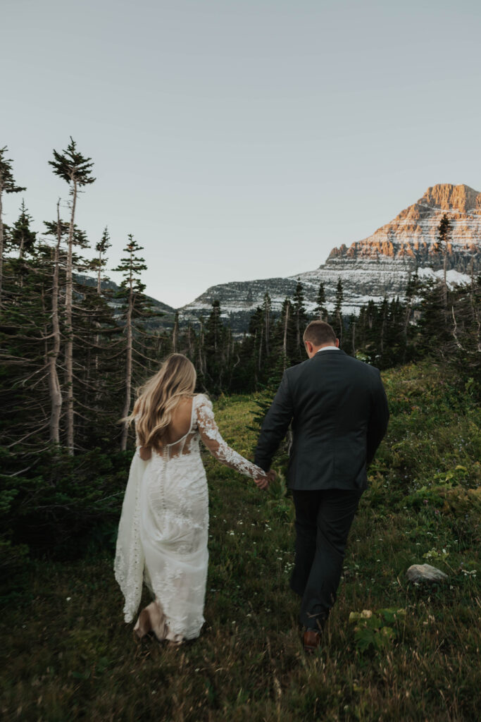 A couple walking towards mountains in Glacier National Park