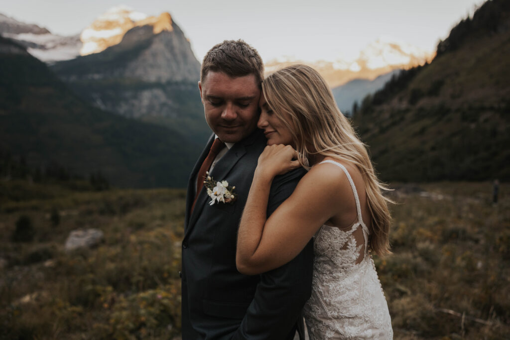 An elegant bride and groom in front mountains for their wedding in Glacier National Park