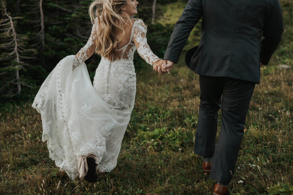 A couple running together and holding hands at Glacier National Park