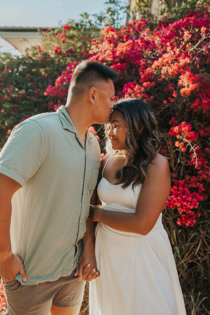 Couple in front of flowers on Po'olenalena Beach in Maui.