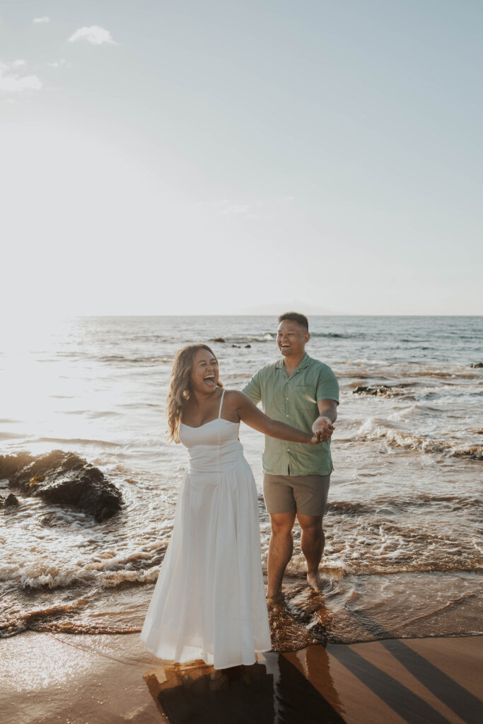 Playful couple on a beach in Maui, Hawaii.