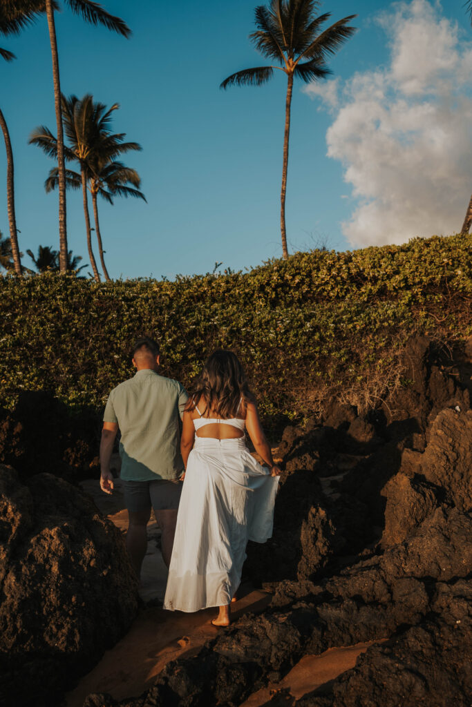 Couple walking near rocks on Po'olenalena Beach, Maui.