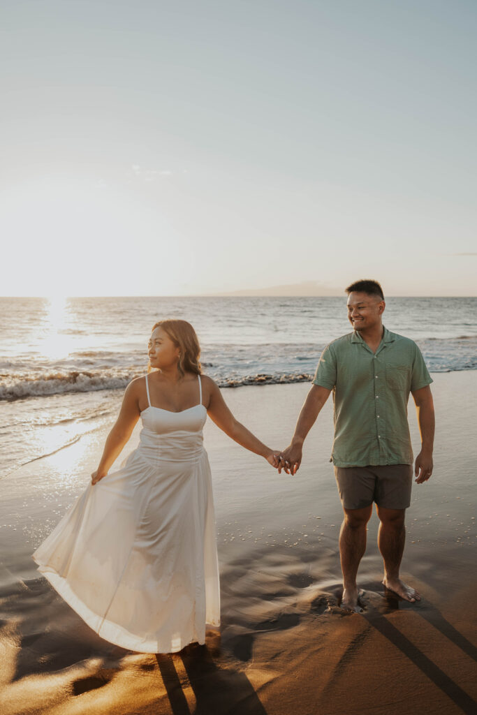 Couple holding hands on Po'olenalena Beach, Maui.