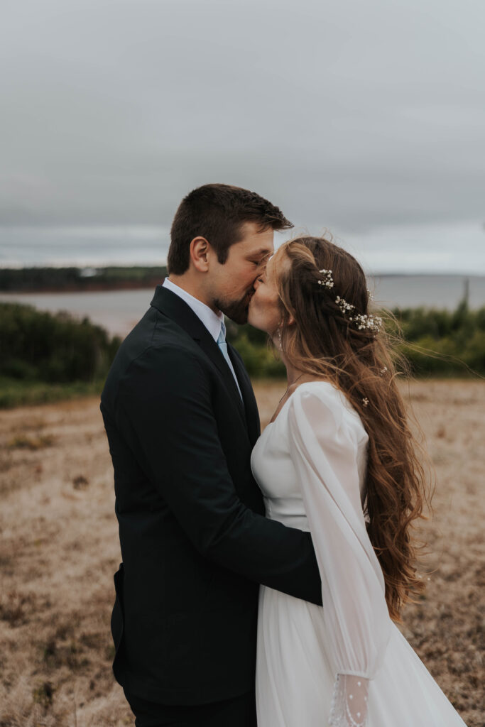 Couple kissing in Prince Edward Island, Canada during their destination wedding