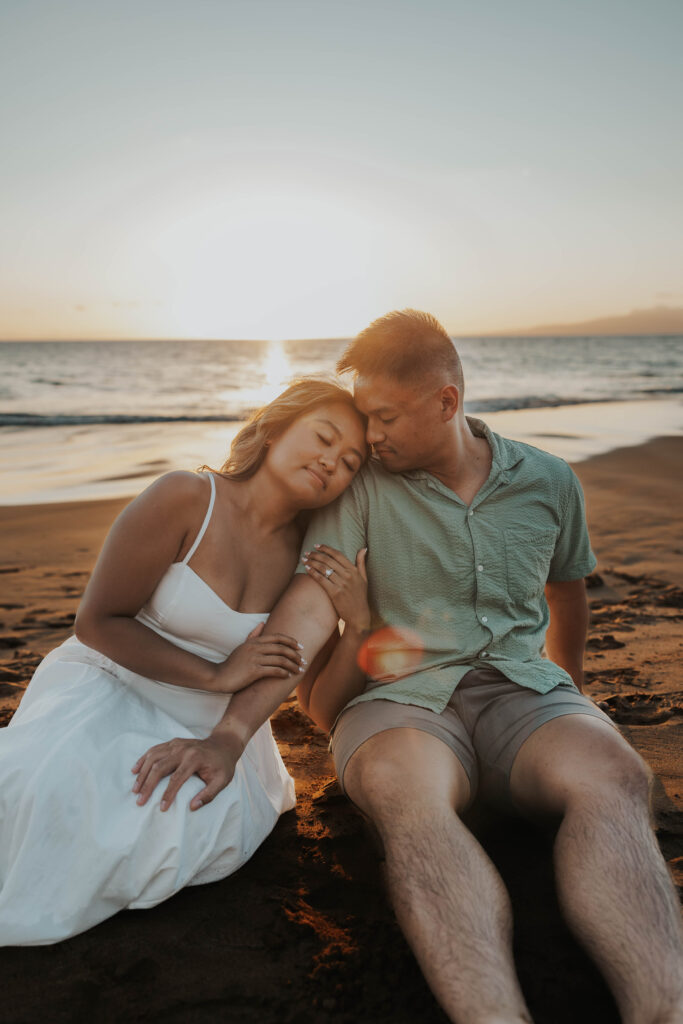 Couple sitting on Po'olenalena Beach in Maui.