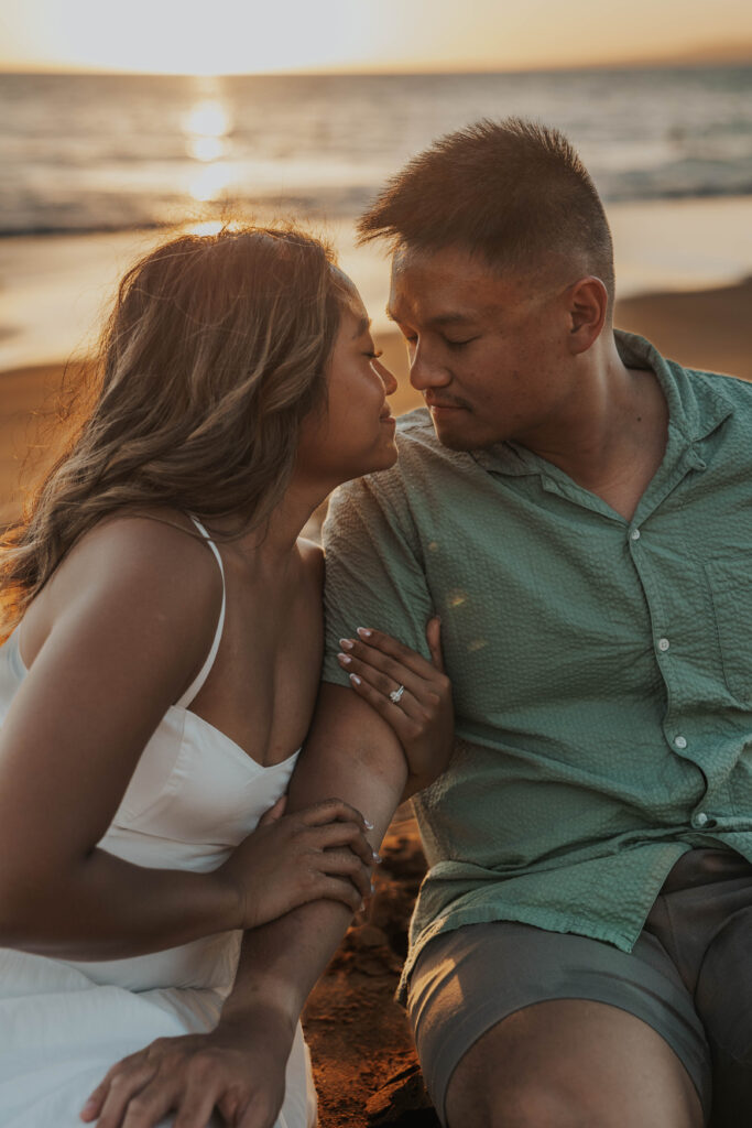 Couple sitting on a Maui beach in Hawaii.