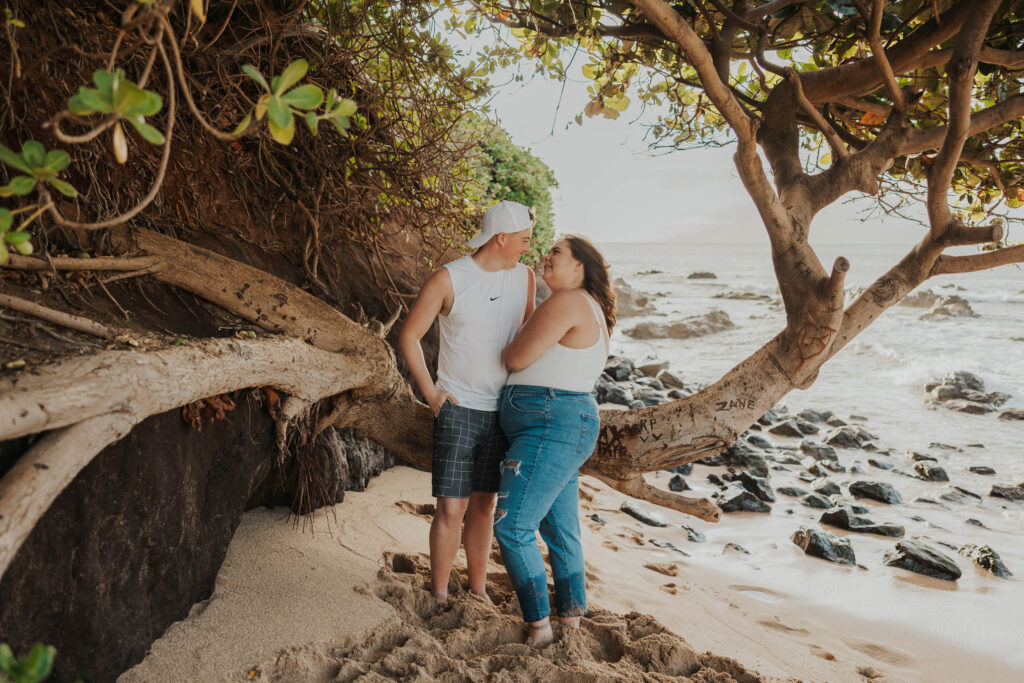 Couple in front of a tree on a beautiful beach in Hawaii