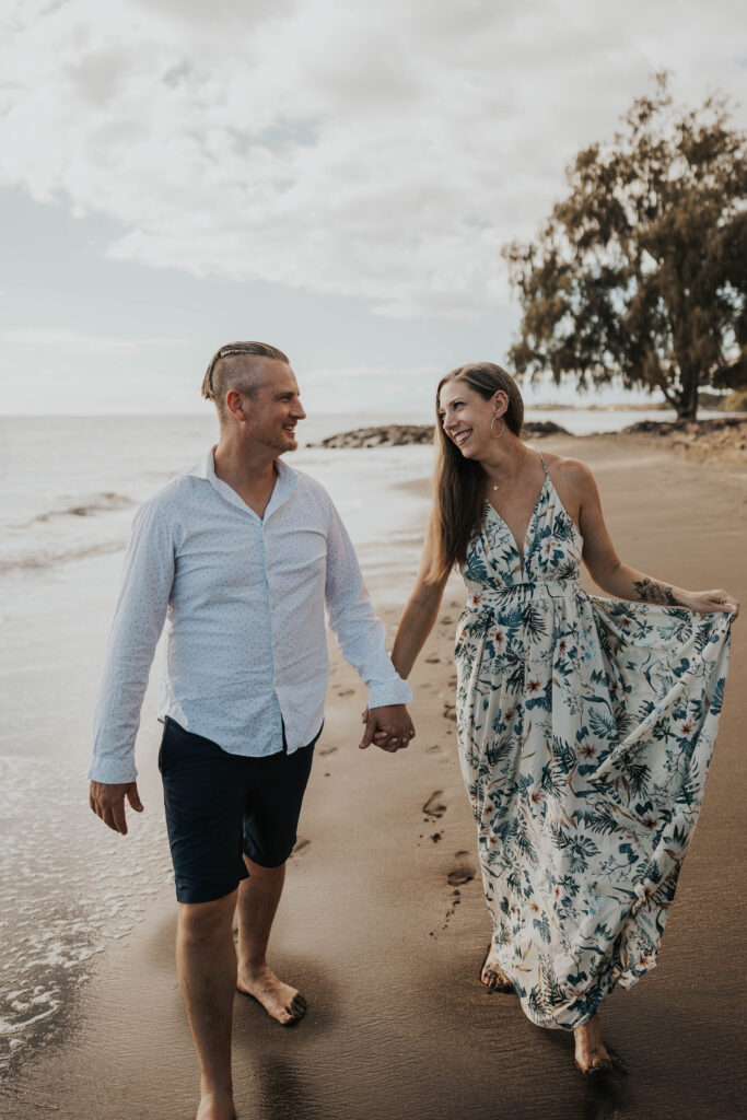 Couple holding hands on a beach in Hawaii