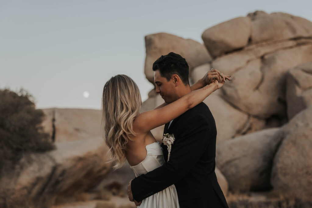 Couple in front of big boulders in Joshua Tree National Park