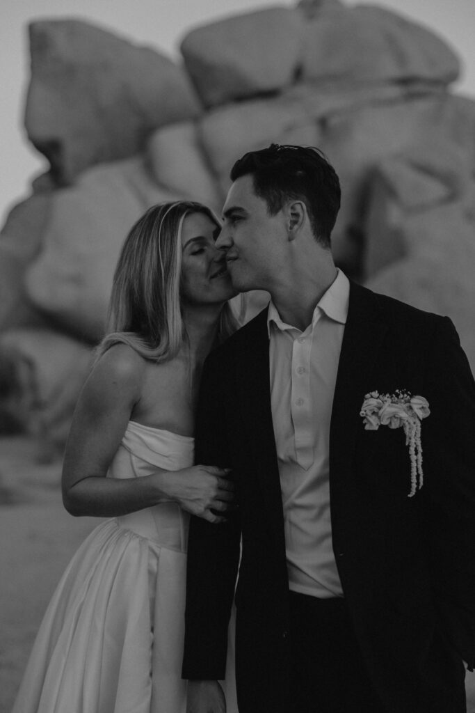 Black and white image of a couple during their elopement standing in front of boulders